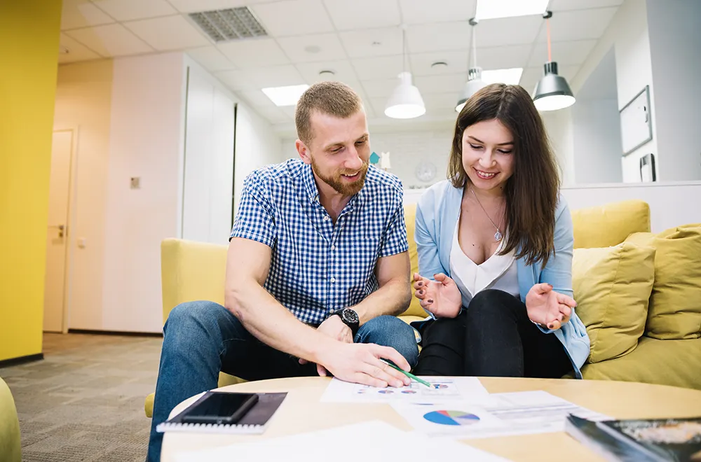 man and woman sitting infront of table with documents on it