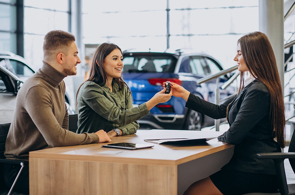couple at a car dealership receiving their new car keys